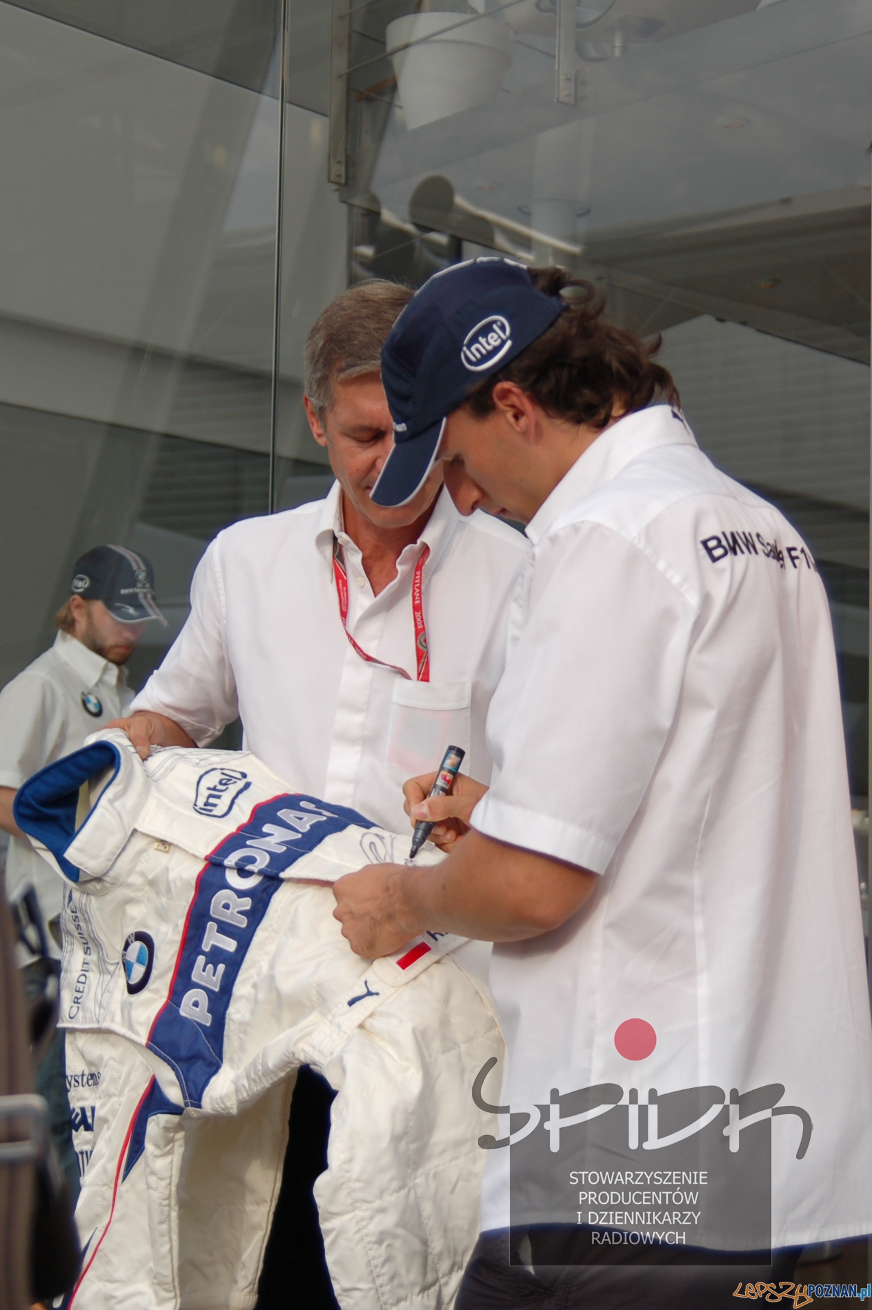 Robert Kubica składa autograf na kombinezonie, w którym zdobył jedyne w swojej karierze pole position Foto: Stowarzyszenie radiowiec Robert Kubica składa autograf na kombinezonie, w którym zdobył jedyne w swojej karierze pole position Foto: Stowarzyszenie radiowiec